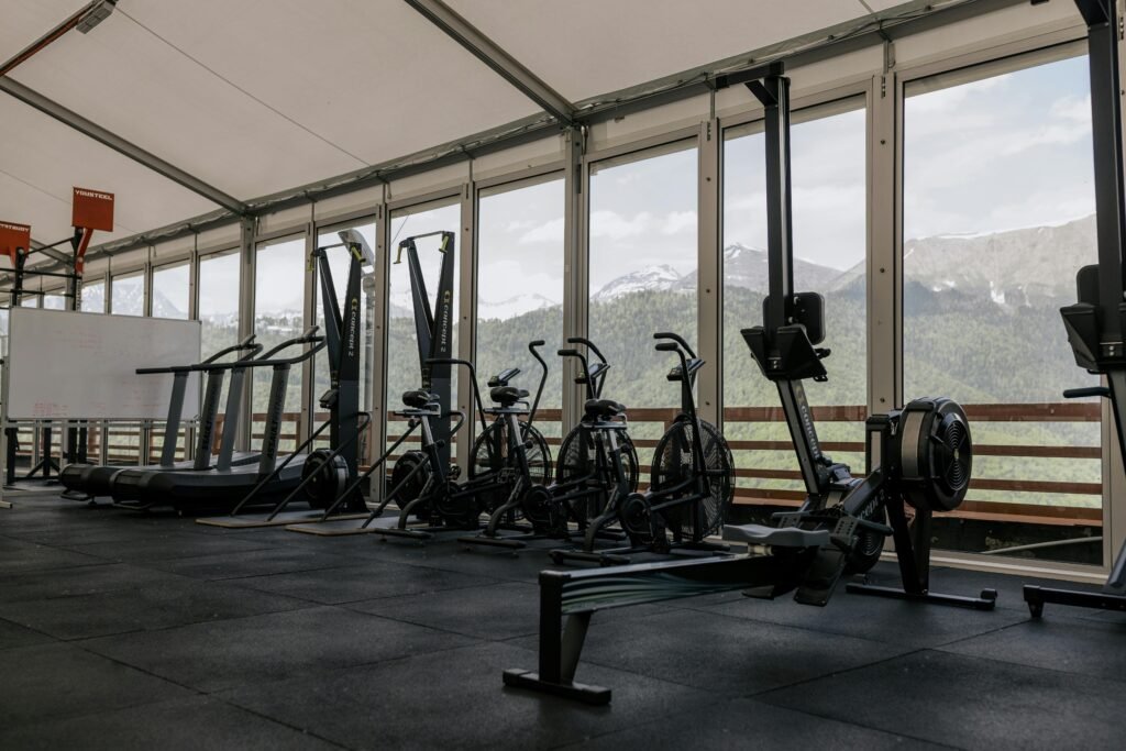 services-1 Spacious indoor gym featuring state-of-the-art equipment with scenic mountain views outside large windows.