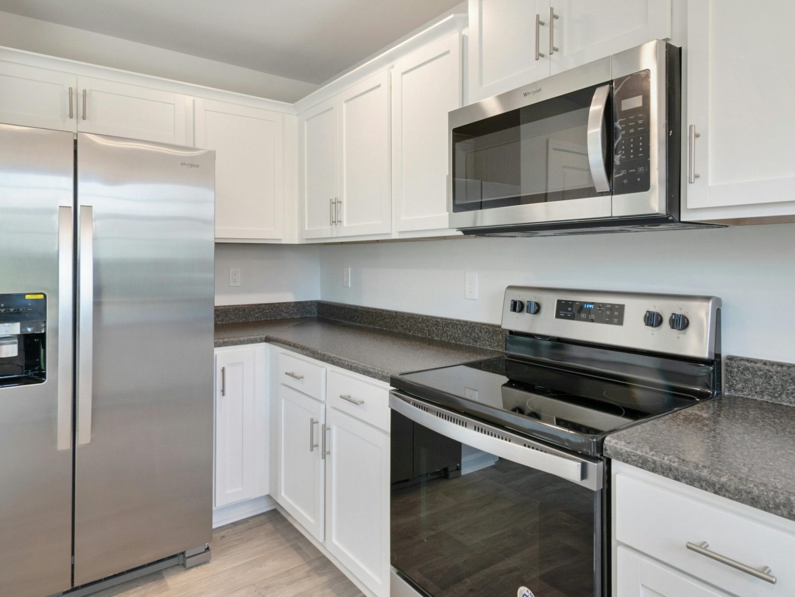 service-3 Sleek kitchen with stainless steel appliances and white cabinetry.