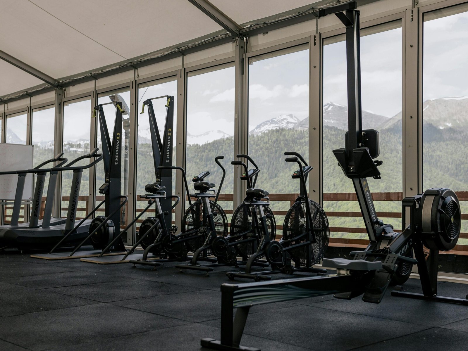 services-1 Spacious indoor gym featuring state-of-the-art equipment with scenic mountain views outside large windows.
